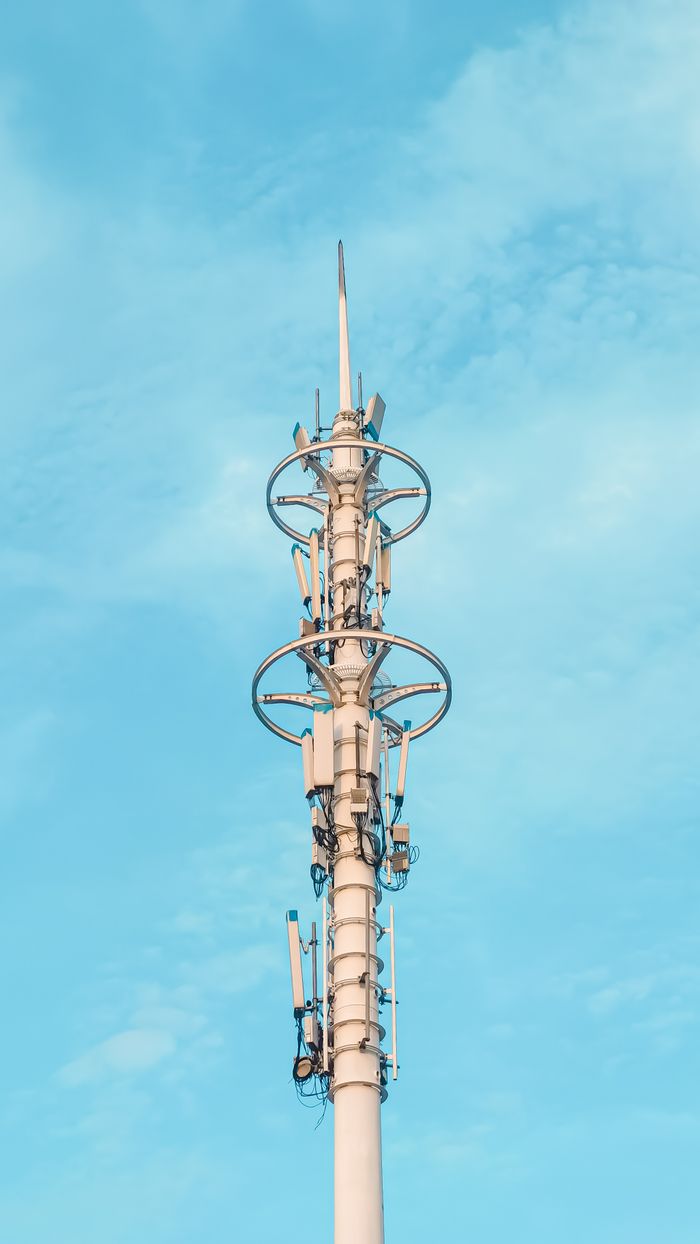A tall antenna tower stands against a background of clear blue sky, showcasing modern communication equipment.