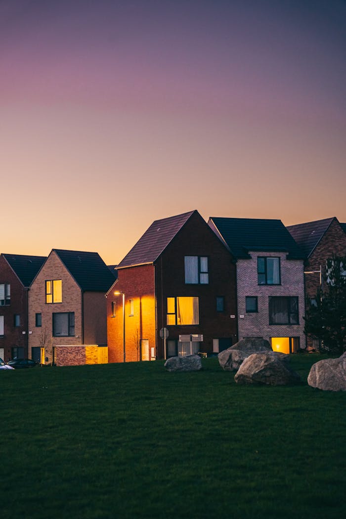 Modern suburban houses with stone accents under a twilight sky.